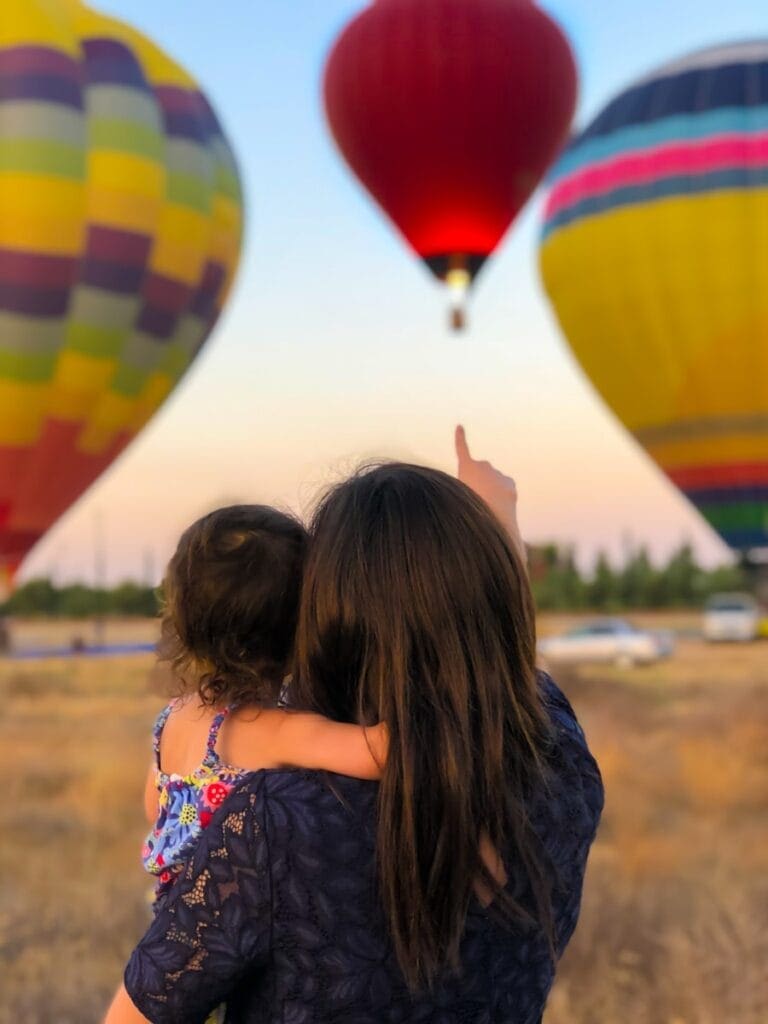 Woman with toddler watching hot air balloon. Gastric Band Hypnotherapy