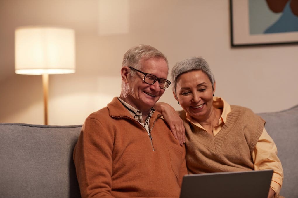 Man and Woman Sitting on Sofa While Looking at a Laptop. Clinical Hypnotherapy Cannon Hill. Hypnotherapy Services.