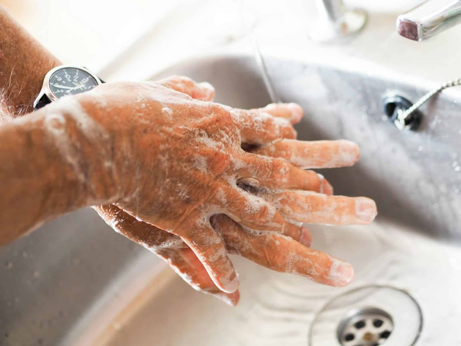 Person washing hands at sink using soap. Handwashing for parasite prevention. Reducing your Body's Toxin Burden. Brisbane Livewell Clinic.