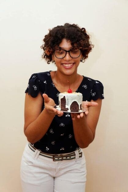 woman in black and white polka dot shirt holding a chocolate cake. Sugar Addiction Science