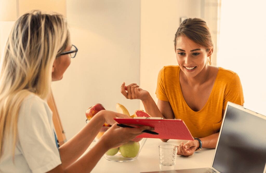 Patient looking at notes held by her Nutritionist