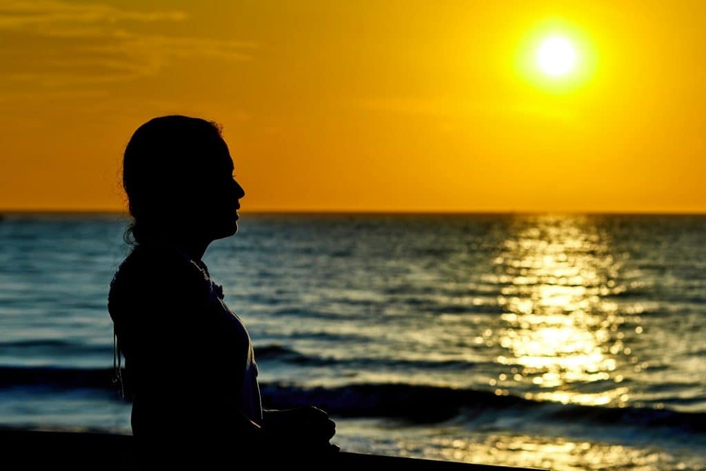 Woman standing at beach during sunset. Hypnotherapy for Anxiety. Brisbane Livewell Clinic