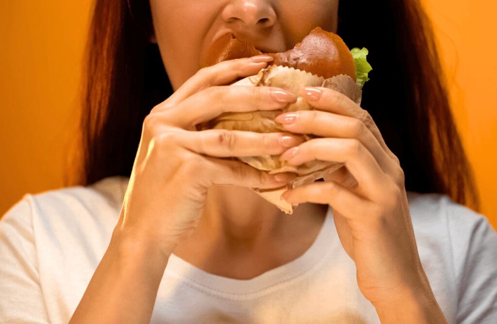 Woman eating unhealthy snack. Hypnotherapy Weight Loss Near Me. Brisbane Livewell Clinic