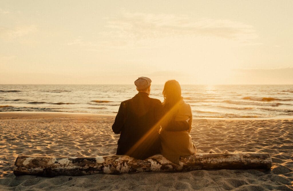 Couple sitting on a log near the beach. Food Allergy Testing Near Me. Brisbane Livewell Clinic