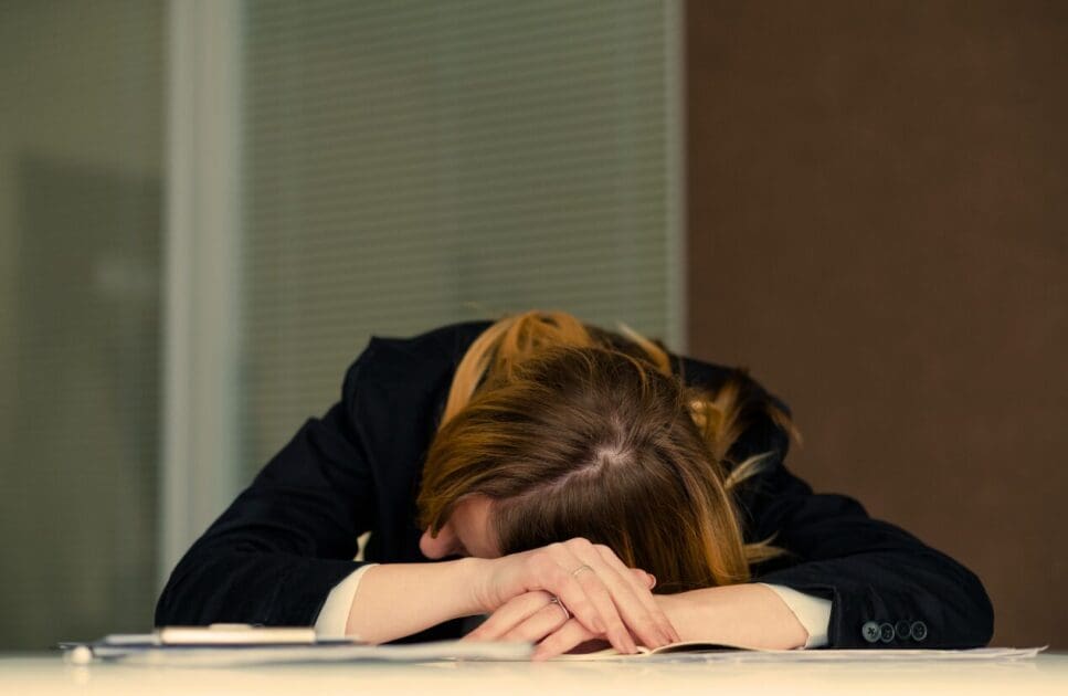 Woman resting on the office desk. Dealing with Adrenal Fatigue. Brisbane Livewell Clinic