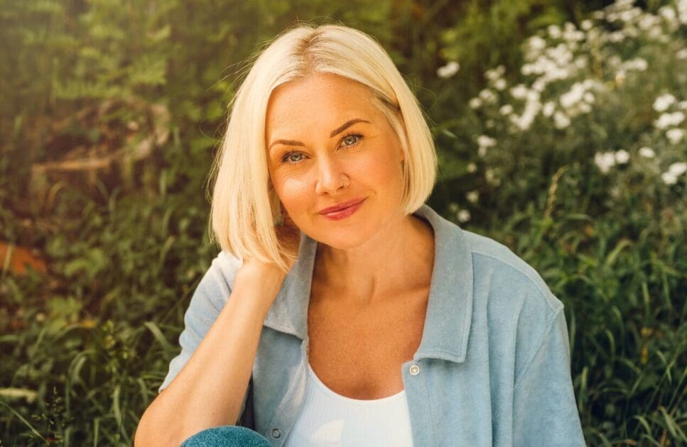 Woman in her 40s sitting outdoors surrounded by nature. Managing Menopause. Menopause. Shella Hall. Clinical Hypnosis for Menopause. Hypnotherapy. Brisbane Livewell Clinic