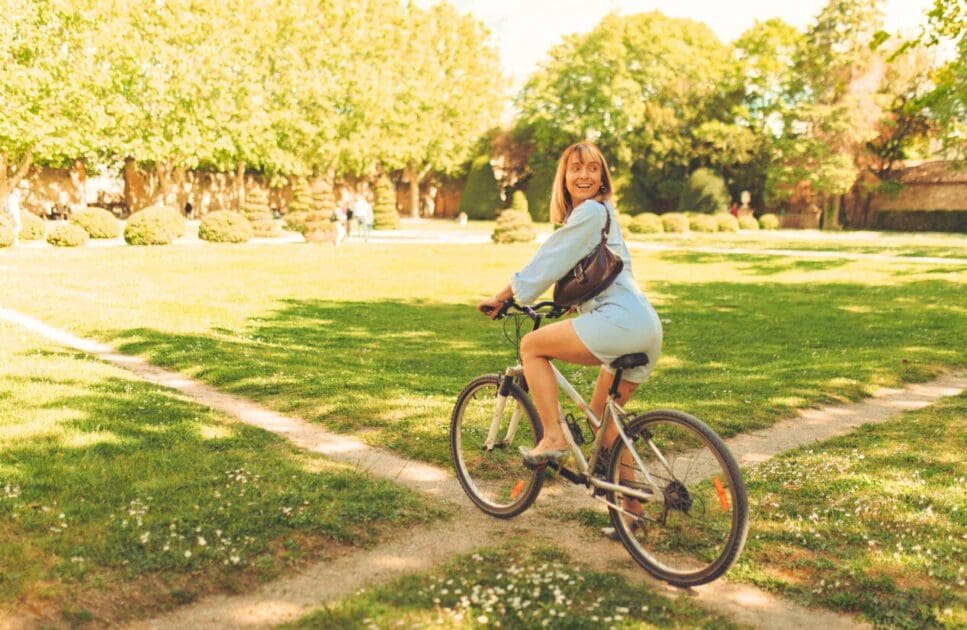 Woman riding a bike in the park. Naturopath Noosa. Osteopath for Knee Pain. Brisbane Livewell Clinic