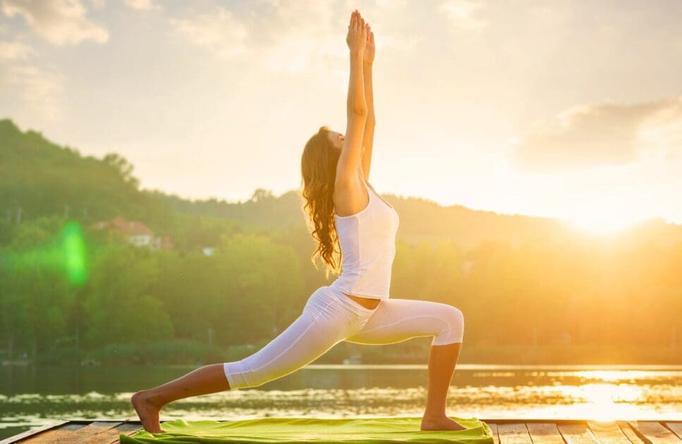 Woman doing yoga during sunrise. IBS. Migraine. Brisbane Livewell Clinic