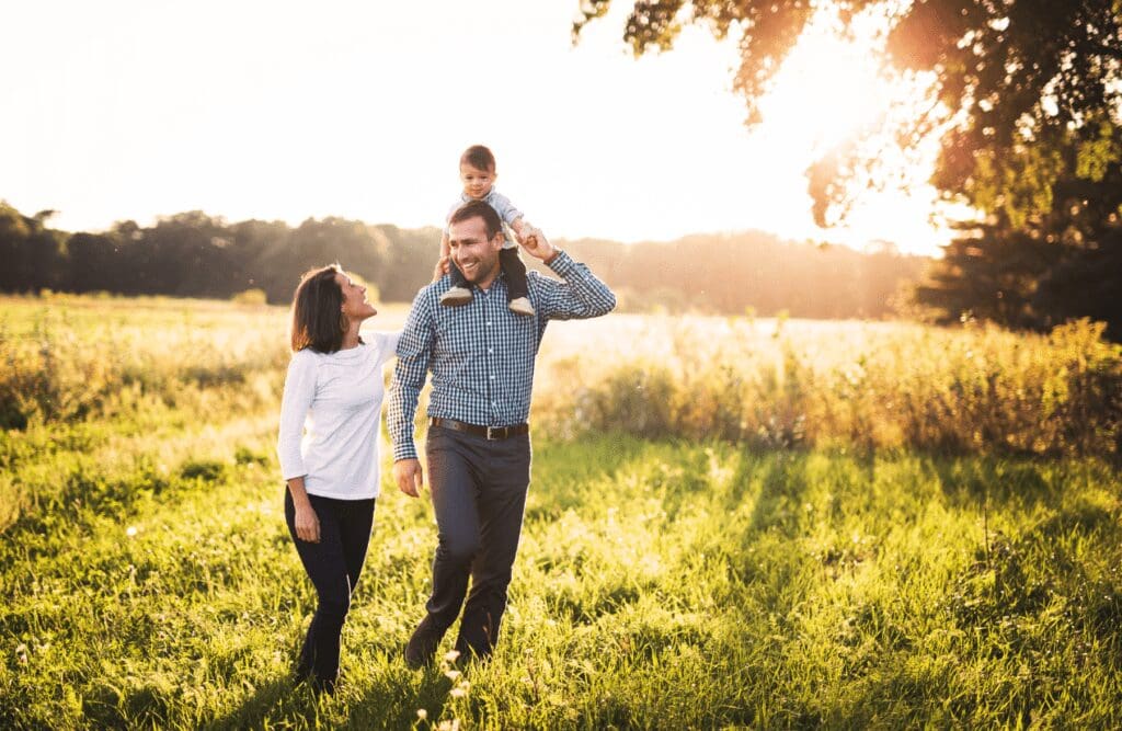 A family of three having fun in an open field on a sunny day. Weight loss hypnosis. Hypnotist Near Me. Brisbane Livewell Clinic