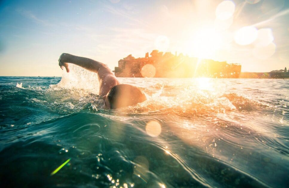 Man swimming in the ocean. IBS. Osteopath for Sports Injuries. Brisbane Livewell Clinic