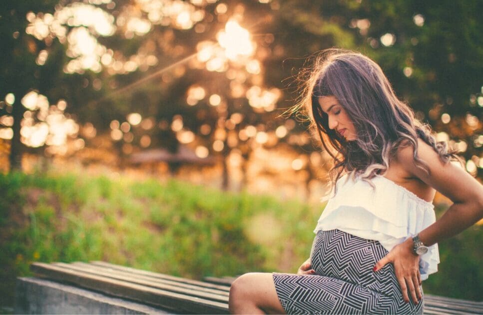 Pregnant woman sitting on the park bench. Pregnancy Massage Near Me. Brisbane Livewell Clinic