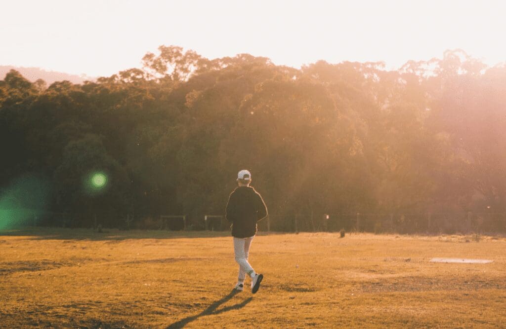 Man walking on a green grass field. Hypnosis Therapy in Melbourne. Osteopath for Foot Pain and Plantar Fasciitis. Brisbane Livewell Clinic