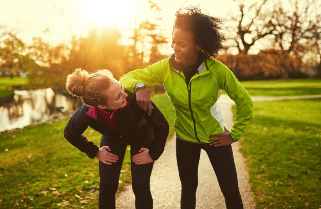 Two women resting after jogging in the park. Naturopaths. Osteopath Carina. Elbow Discomfort Osteopath. Brisbane Livewell Clinic