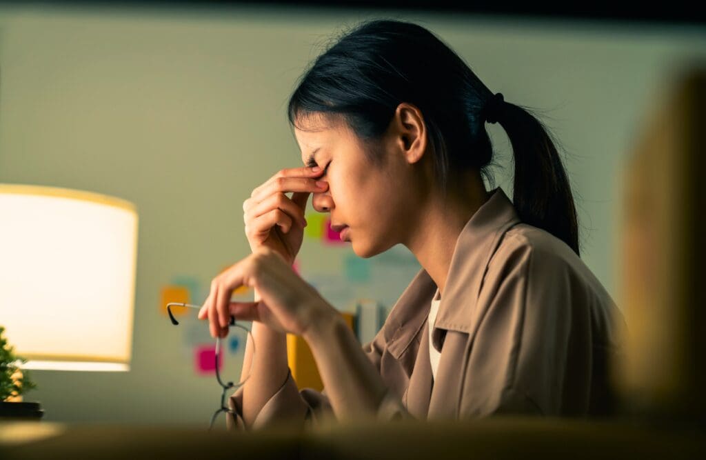 Woman experiencing headache at work. Food Intolerance Testing. How to Get an Allergy Test in Australia. Osteopath for Headaches. Brisbane Livewell Clinic