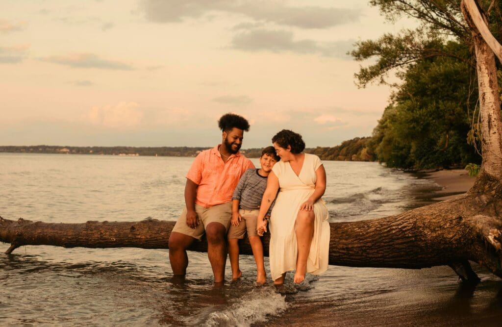 Family sitting on a tree log near the beach. Clinical Hypnotherapy Murarrie. Naturopaths Brisbane. Gut-Brain Connection. Gastric Band Hypnosis. Brisbane Livewell Clinic