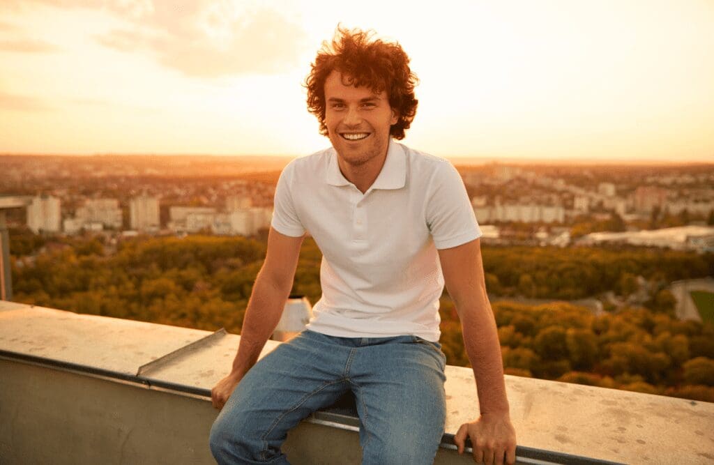 Man sitting on a rooftop edge. Hypnotherapy FAQs. Bowen Therapy on the Sunshine Coast. Naturopath Toowoomba. Masking Recovery Holistic Counselling. Brisbane Livewell Clinic