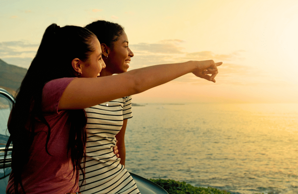 Woman pointing towards the ocean. Naturopath Noosa. Osteopath for Neck Pain and Headaches. Brisbane Livewell Clinic
