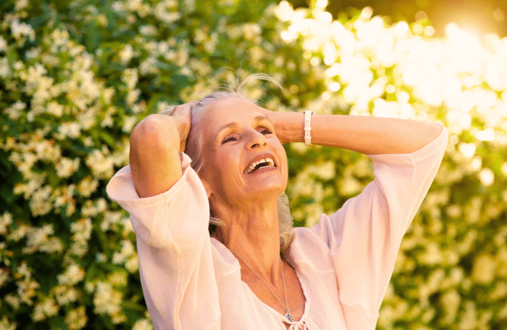 Happy middle-aged woman standing in the garden. Gut Microbiome Testing Australia. Full body massage in Brisbane. Clinical Hypnosis for Menopause. Brisbane Livewell Clinic