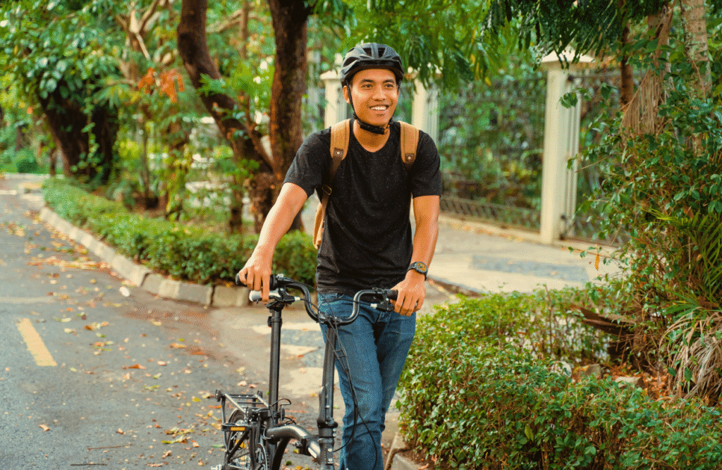 Man walks with his bicycle down the street. Gut Microbiome Testing Australia. Osteopathy vs Chiropractic vs Physiotherapy. Osteopath for Sciatica. Brisbane Livewell Clinic