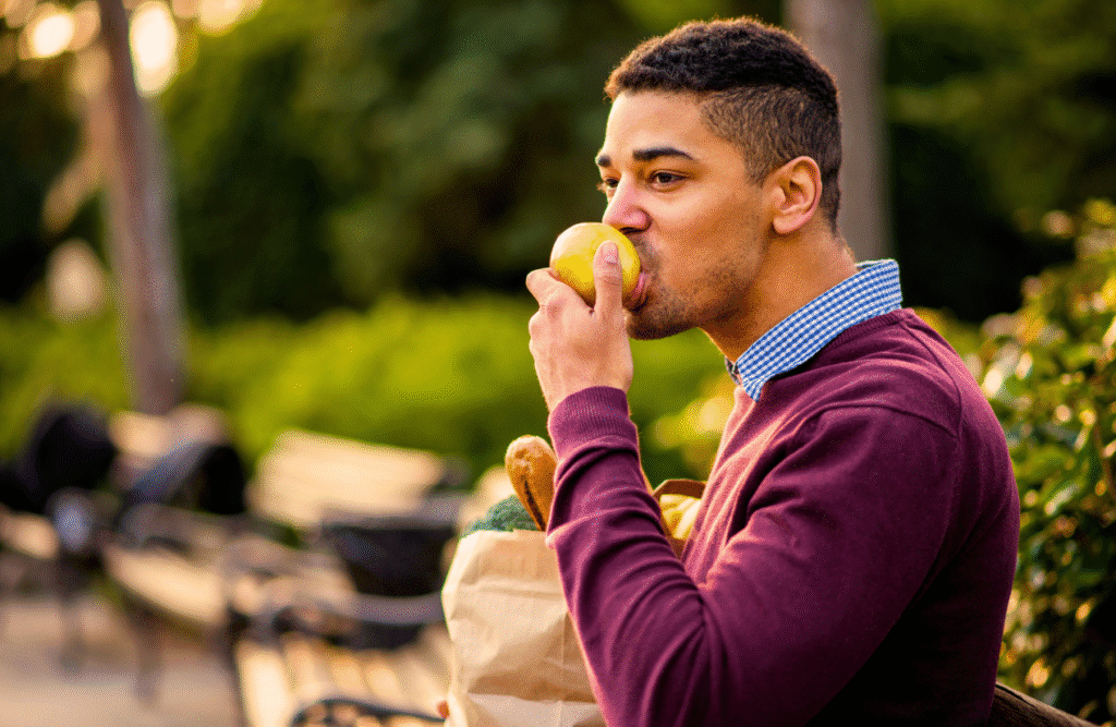 Man eating fruits in the park. Mood & Food. Recovery after Viral Infection. Sperm Health. Clinical Nutritionist Carina. Brisbane Livewell Clinic