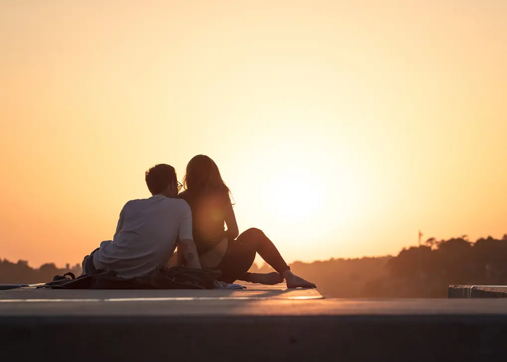 Couple sitting on a rock during golden hour. Counselling Locations