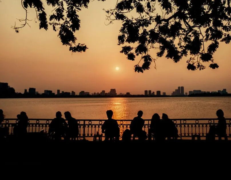 People sitting on a bench near the body of water, watching the sunset. Hypnotherapy near Wooloowin. Bridgeman Downs. Brisbane Livewell Clinic