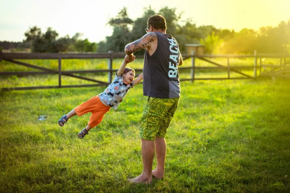Father and son enjoying playtime in a field as the sun sets. Hypnotherapy near Stafford Heights. Osteopath Tingalpa. Brisbane Livewell Clinic