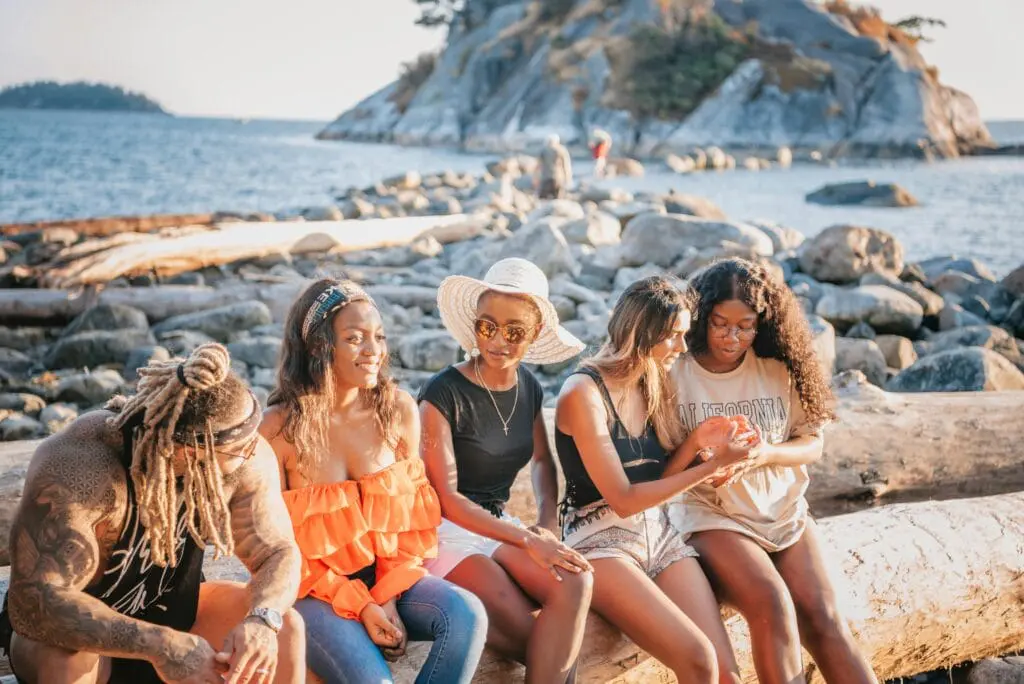 Friends sitting on rocks near the seashore. Counselling Wooloowin. Brisbane Livewell Clinic