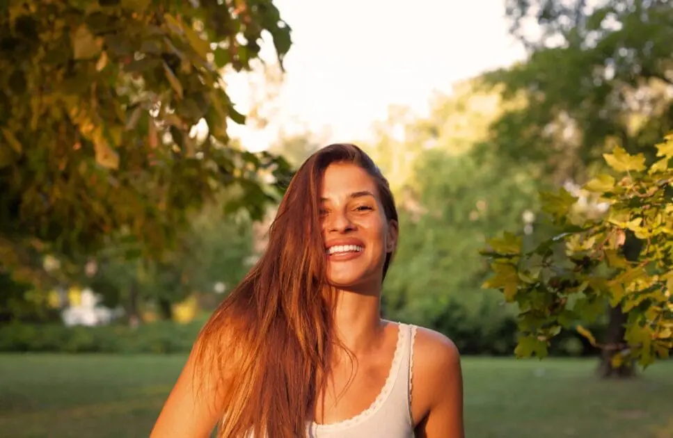 Smiling woman sitting on a bench. Treating Depression with Naturopathy. Brisbane Wellbeing. Test Cortisol at Home. Naturopath Anxiety. Osteopath for Shoulder Pain and Arm Discomfort. Brisbane Livewell Clinic