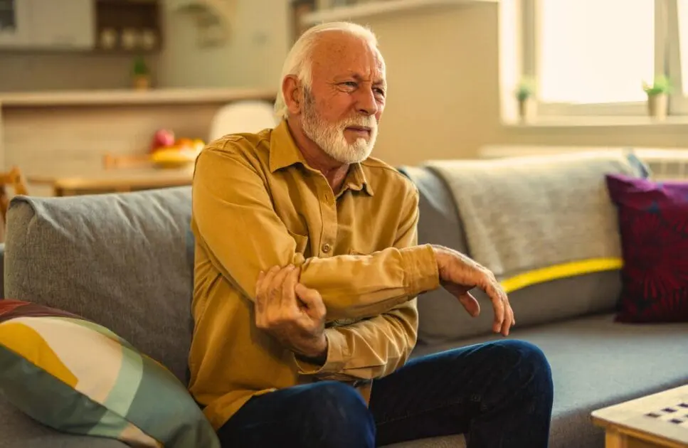 Man experiencing elbow pain. Vulnerable to Osteoarthritis. Elbow Discomfort Osteopath. Brisbane Livewell Clinic