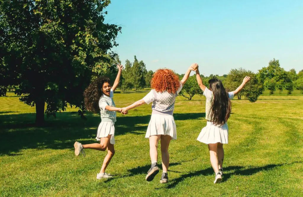 Three female friends enjoying sunny day on the grass field. Counselling Geebung. Brisbane Livewell Clinic