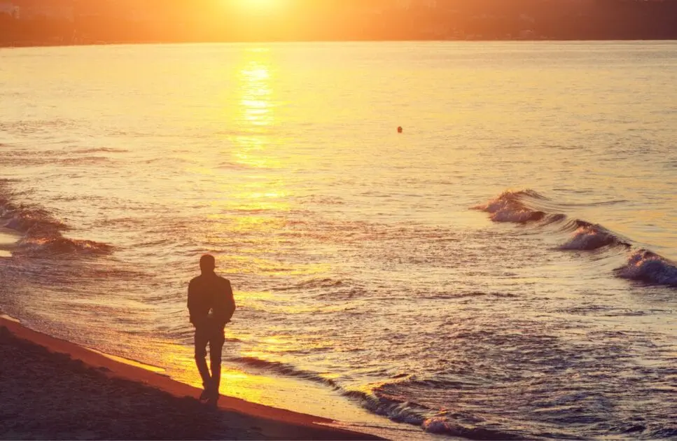 Silhouette of man walking alone on the beach at sunset. Hypnotherapy near Clayfield. Brisbane Livewell Clinic