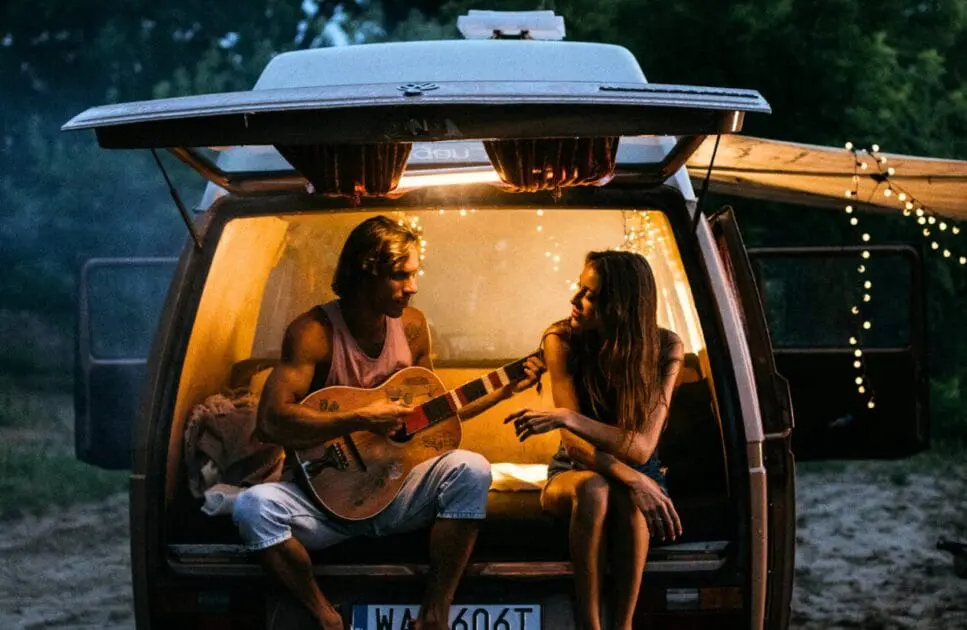 Man playing a guitar next to a woman in the camper van. Counselling Camp Hill. Brisbane Livewell Clinic. Methylation Test Near Me