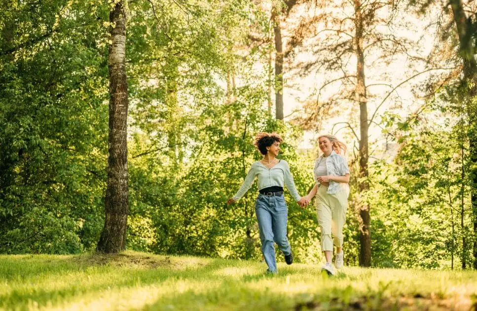 Two women running in the woods together on a sunny day. Hypnotherapy near Northgate. Brisbane Livewell Clinic