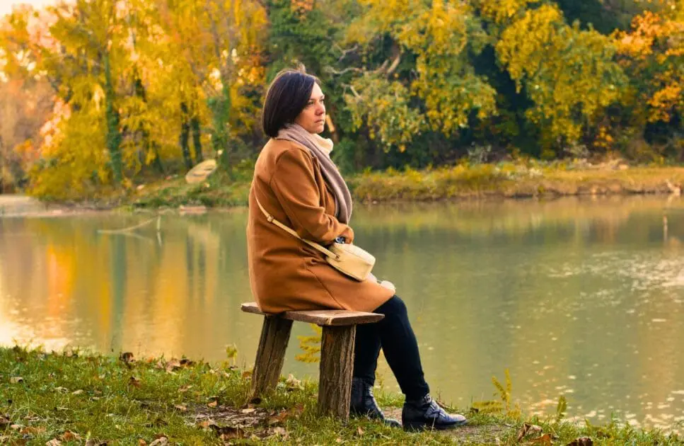 Woman sitting on a bench by a lake. Counselling the Bereaved. Mindset Therapy Brisbane. Brisbane Livewell Clinic