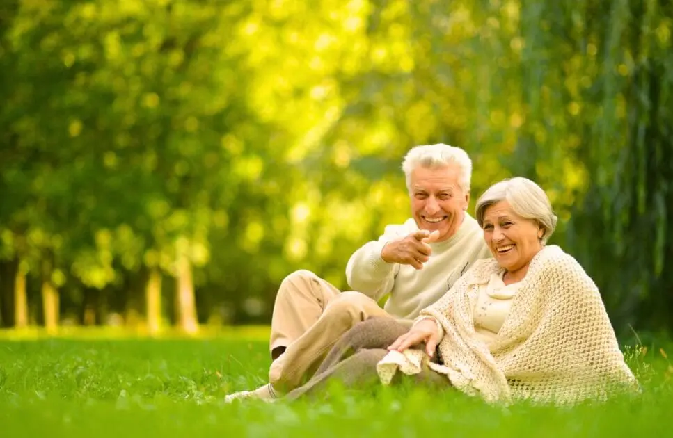 Couple relaxes on the grass in a park, surrounded by nature. Marriage Counselling. Iron Deficiency. Brisbane Livewell Clinic