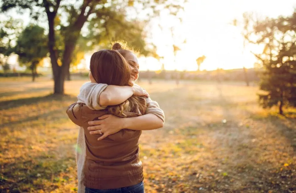 Two women hugging in a park, displaying comfort. Grief Counselling. Counselling Brisbane. Masking Recovery Holistic Counselling. Counselling Nundah. Brisbane Livewell Clinic