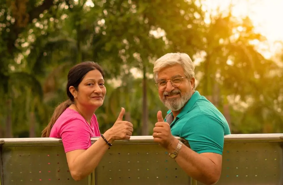 Smiling couple sitting on a bench, giving a thumbs up. Couples Counselling Brisbane. Naturopath. Brisbane Livewell Clinic